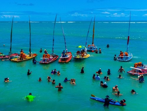 Playa en Maceió con varios barcos y personas en el agua