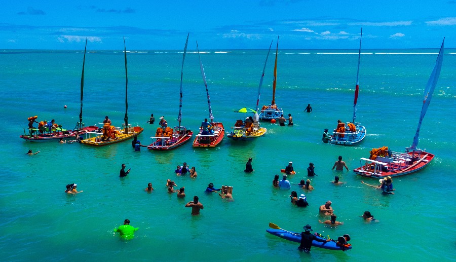 Playa en Maceió con varios barcos y personas en el agua