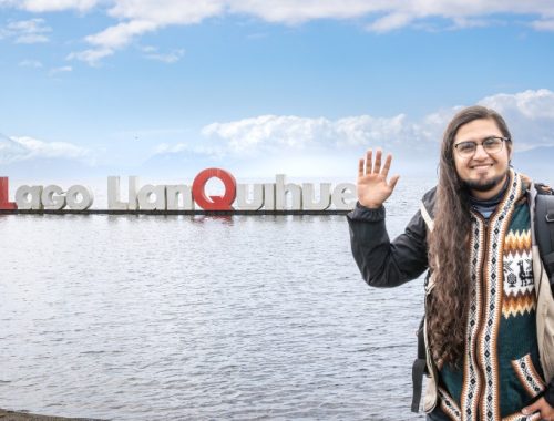 Hombre saludando para una foto frente al Lago Llanquihue