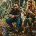 Pareja feliz acampando en Cajón del Maipo alrededor de una fogata