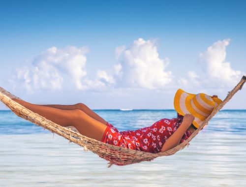 Persona relajándose en una hamaca frente al mar