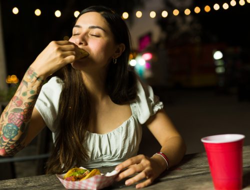 Mujer feliz comiendo comida mexicana