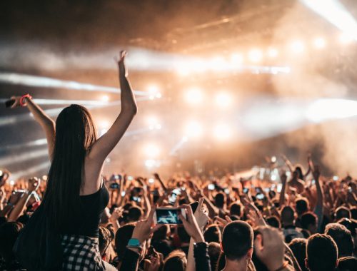 Mujer disfrutando de un concierto sobre el hombro de su amigo