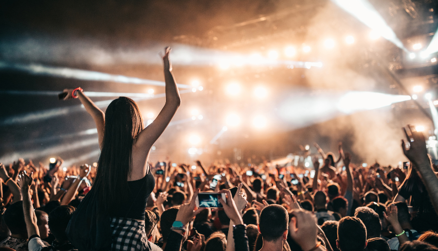 Mujer disfrutando de un concierto sobre el hombro de su amigo