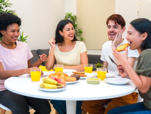 Grupo de amigos desayunando juntos en una casa alquilada a través de Couchsurfing