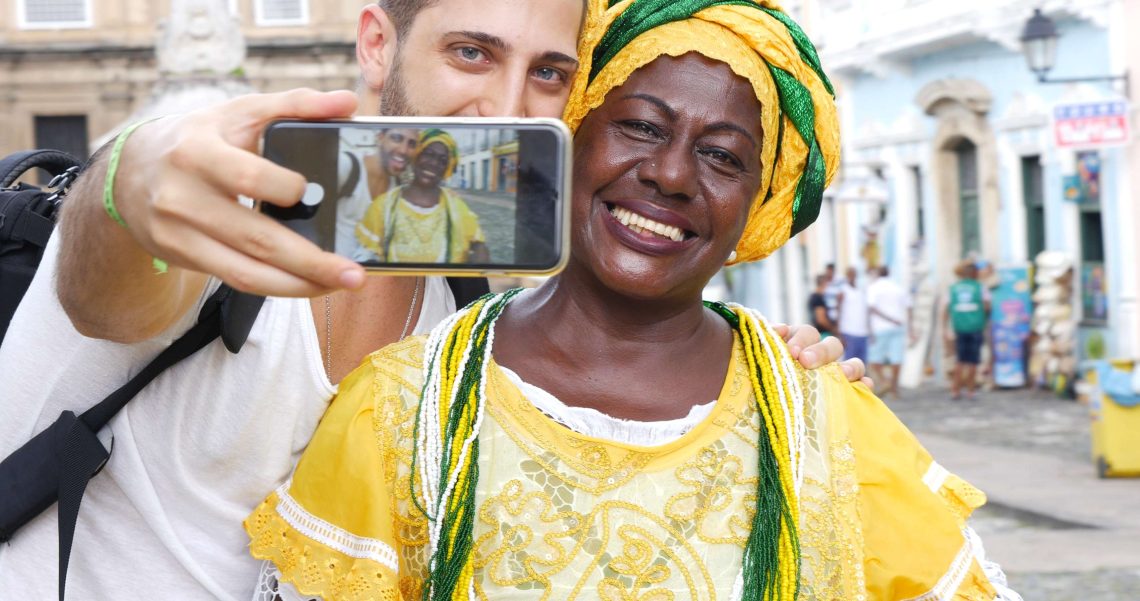 Hombre tomando una foto con una brasileña vestida con traje típico de una celebración local