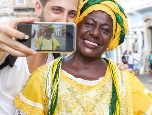 Hombre tomando una foto con una brasileña vestida con traje típico de una celebración local