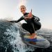 Mujer surfeando y haciendo una señal para posar en una foto