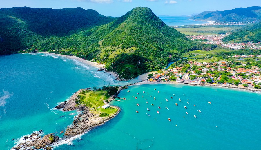 Paisaje de playa con aguas cristalinas y montañas verdes