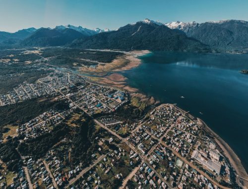 Imagen de la ciudad de Hornopirén, rodeada por montañas y mar con aguas cristalinas