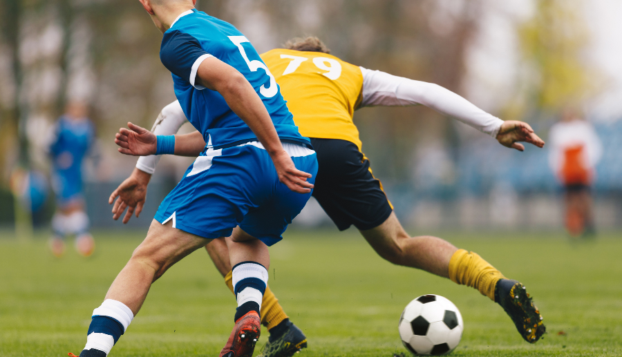 Jugadores en un partido de fútbol disputando el balón