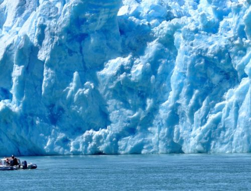 Hombres dentro de un barco frente al glaciar San Rafael.