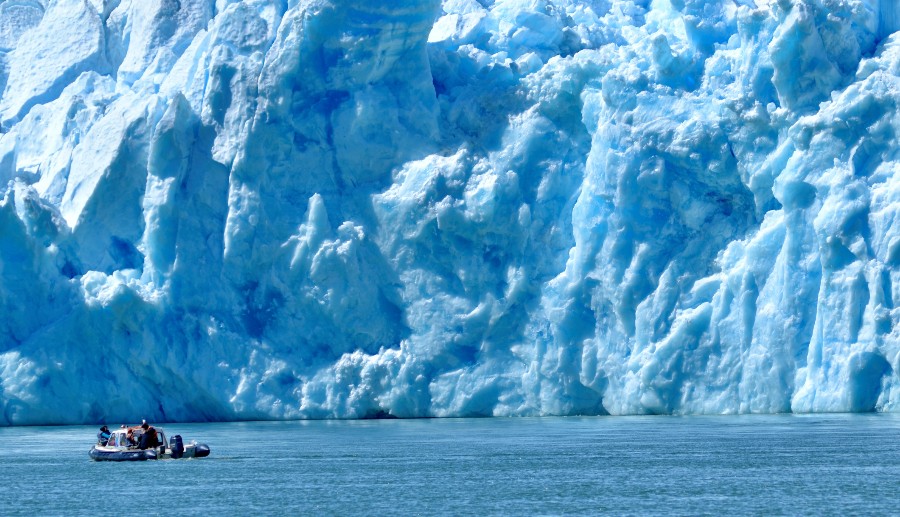 Hombres dentro de un barco frente al glaciar San Rafael.