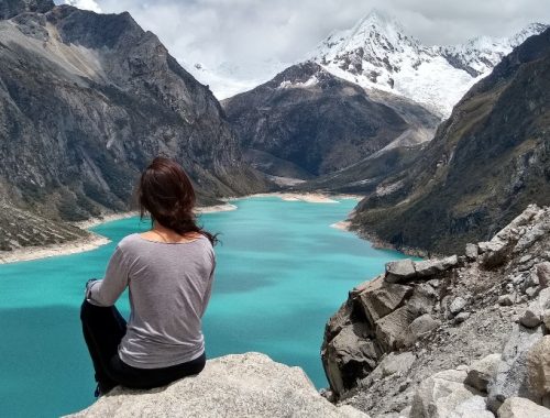 Mujer tomando una foto de espaldas observando el paisaje de la ciudad de Huaraz