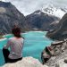Mujer tomando una foto de espaldas observando el paisaje de la ciudad de Huaraz