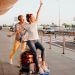 Pareja divirtiéndose mientras transporta las maletas en el aeropuerto