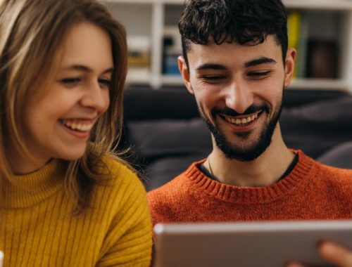 Pareja sonriendo mientras planea su viaje