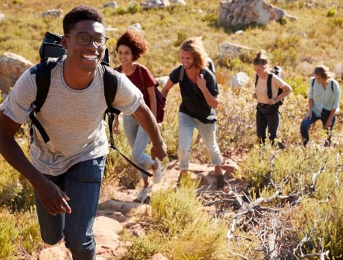 Grupo de amigos con mochilas haciendo senderismo