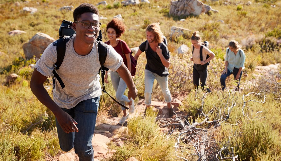Grupo de amigos con mochilas haciendo senderismo