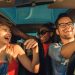 Grupo de amigos felices viajando dentro del coche