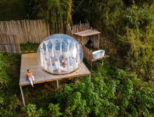 Pareja disfrutando del día en un camping de lujo en medio del bosque