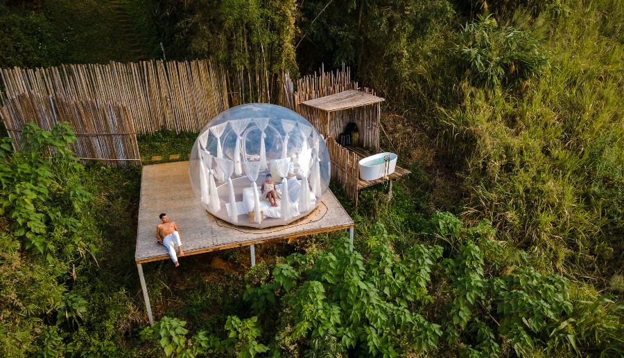 Pareja disfrutando del día en un camping de lujo en medio del bosque