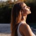 Mujer de cabello largo y ojos cerrados tomando el sol en un retiro espiritual