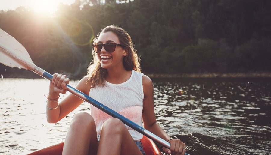 Mujer sonriente remando en canoa en el río Itata.