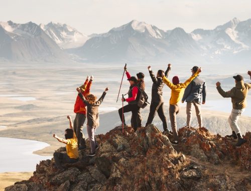 Grupo de personas celebrando haber llegado a la cima de una montaña