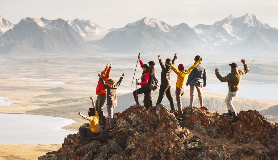 Grupo de personas celebrando haber llegado a la cima de una montaña