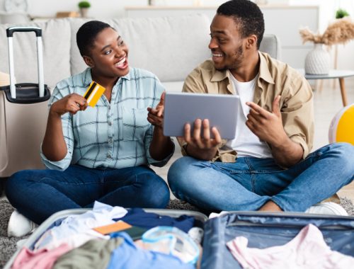 Pareja negra separando maletas y tarjeta para el viaje