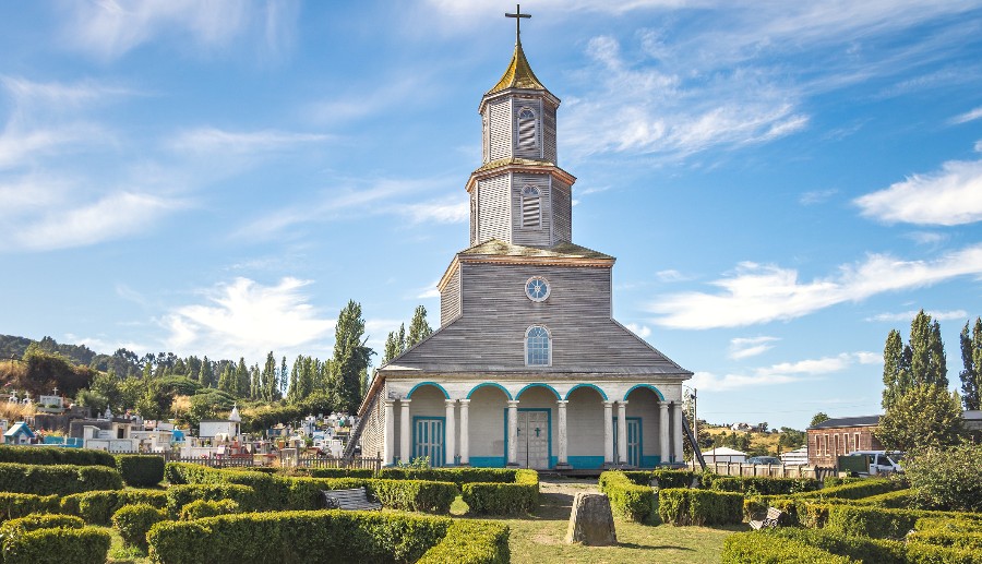 Imagen de iglesia rodeada por casas y céspedes