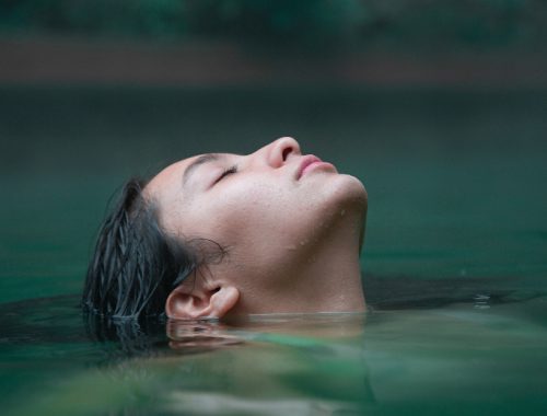 Rostro femenino sumergiéndose en las termas de Cajón del Maipo