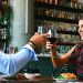 Casal brindando com taça de vinho em restaurante