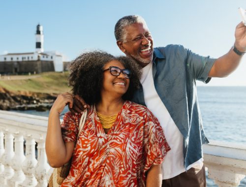 Pareja mayor negra tomándose una foto sonriendo en un sitio turístico