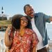Pareja mayor negra tomándose una foto sonriendo en un sitio turístico